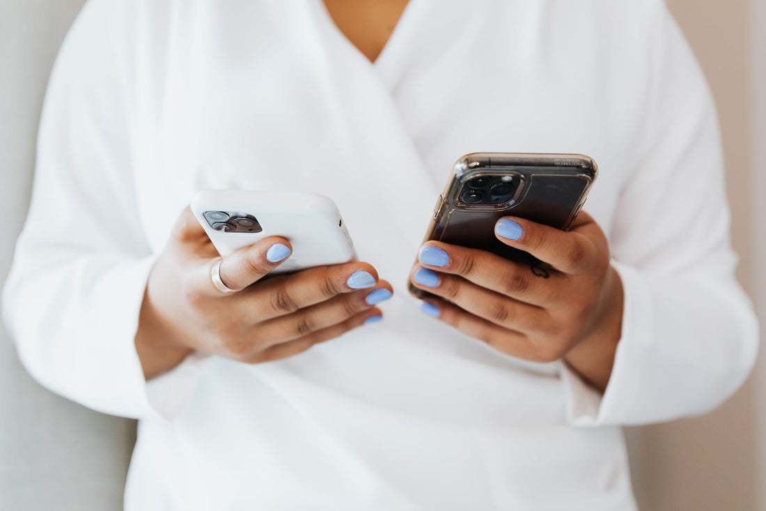 A woman holding two iPhones.